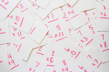 Multiplication flash cards spilled onto a pile; scattered math flash cards background