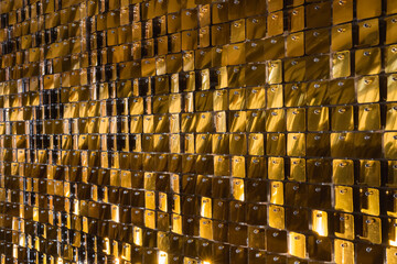 Wall of gilded tiles reflecting light