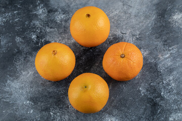 Four tasty oranges on marble background
