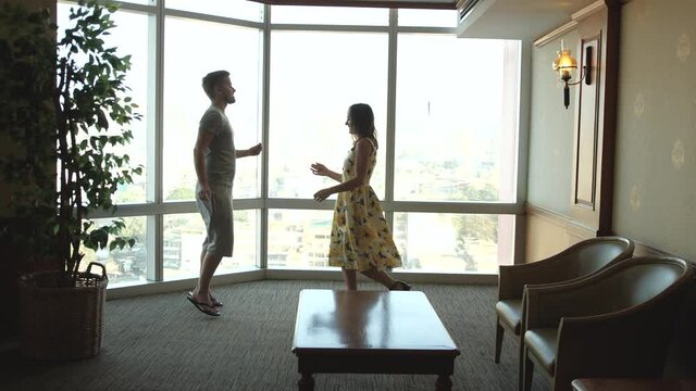 dancing couple against large window