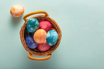 Easter eggs in a basket on a blue background, top view