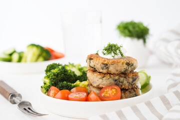 Vegetarian dish of potato patties with herbs and vegetables in a plate