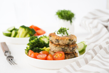 Vegetarian dish of potato patties with herbs and vegetables in a plate