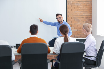 Businessman giving presentation during meeting in office