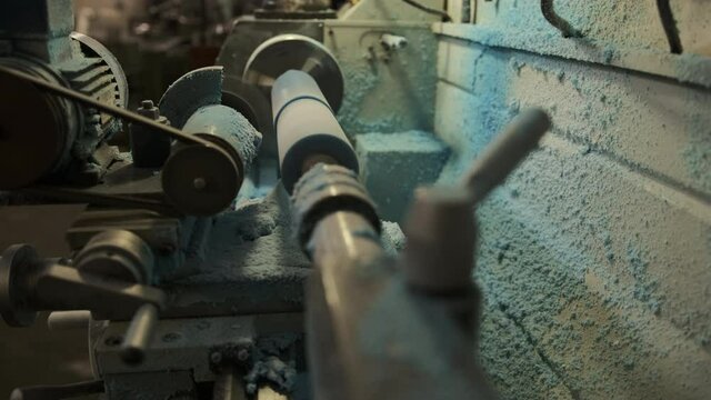 Processing of a polyurethane shaft on a milling equipment. The blue polyurethane roller is milled. Milling work for the production of the required size of parts 