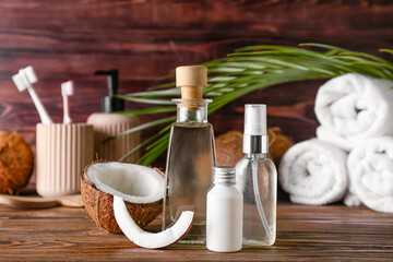 Composition with bottles of coconut oil on wooden background