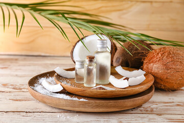 Composition with bottles of coconut oil on wooden background