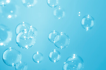 Beautiful shiny transparent blue soap bubbles background.