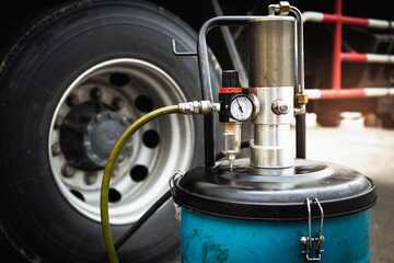 Wheeled Grease Filling Machine. Pressure Gauge Valve. Truck Wheels Maintenance.