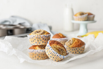 Tasty banana muffins on light background