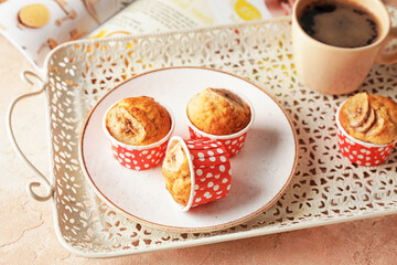 Tray with tasty banana muffins and cup of coffee on table