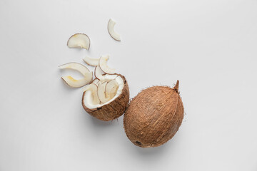 Coconut with tasty chips on light background