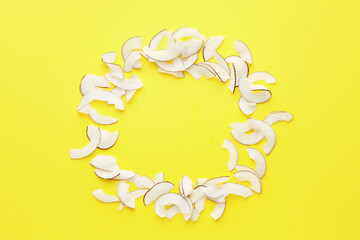 Frame made of tasty coconut chips on color background