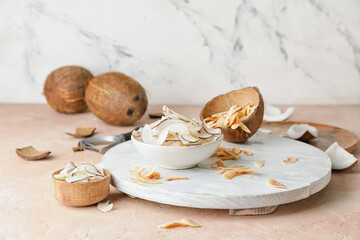 Bowl with tasty coconut chips on table