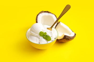 Bowl with tasty coconut ice cream on color background