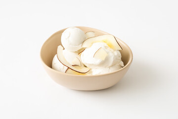 Bowl with tasty coconut ice cream on white background