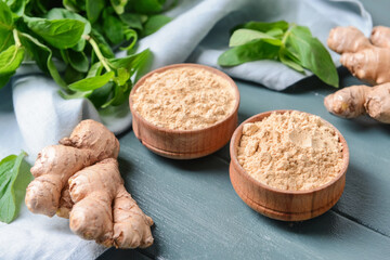Composition with ginger powder on color wooden background