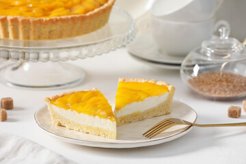 Plate with pieces of tasty mango pie on light background