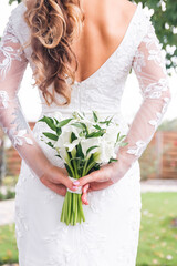 a bouquet of flowers behind the back in the hands of the bride