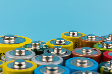 Photo of alkaline batteries on blue background. Recycling of rechargeable NiMH batteries. The...
