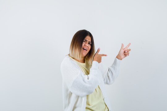  Young Lady In T-shirt, Cardigan Pointing To The Right Side And Looking Energetic , Front View.