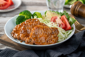 Delicious juicy pork chops with vegetables in a plate.