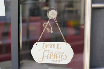 desole nous somme fermes means in french sorry we are closed on wooden sign board wood on windows shop restaurant cafe store signboard