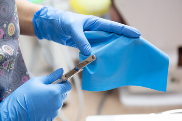 Isolation of the tooth for medical manipulations with a cofferdam. Preparing the rubber dam for use.