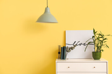 Stylish lamp and chest of drawers near color wall in room