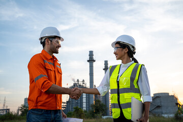 Refinery industry engineer shaking hands other hand at oil refinery site,Success collaboration...