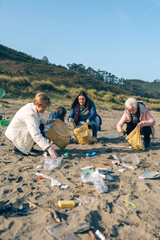 Group of female volunteers picking up trash on the beach