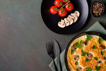 Fresh homemade omelette with mushrooms, parsley and tomatoes. Copy space, top view.