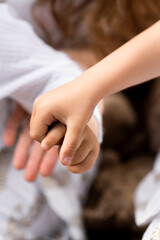 Hands of two children holding hands brother and sister