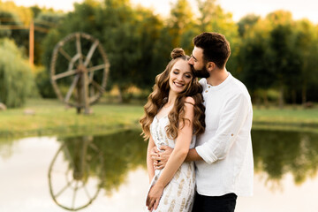 Beautiful man and woman on a lake background on a sunny day