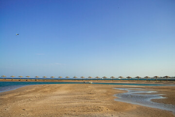 Sunset on the beach with parasol overlooking the Red Sea in Hurghada, Egypt