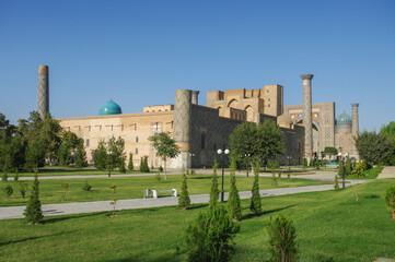 Fototapeta na wymiar Landscape view of famous medieval Registan Square viewed from surrounding garden with Ulugh Beg madrassa in foreground, Samarkand, Uzbekistan