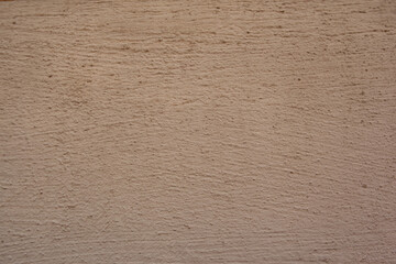 Vintage background texture concrete wall colored plaster. Stucco wall texture. Dense grain texture made with tiny stones, earthy colors, on a wall background. Backdrop dirty light brown cement wall.