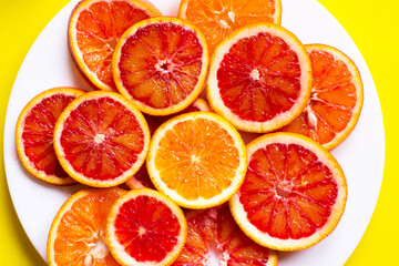 citrus fruit slices on the plate. Top view, yellow background