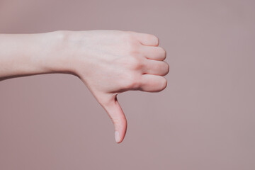 Female hand showing thumb down gesture. Hand signs communication concept