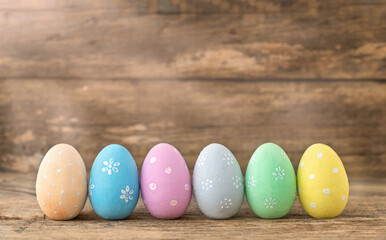 Painted Easter eggs arranged in a row on a wooden background
