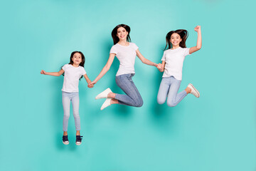 Fototapeta na wymiar Full length body size photo sisters jumping up wearing jeans white t-shirts happy won lottery isolated bright blue color background