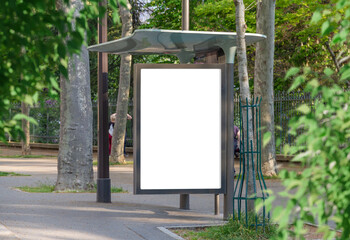 Bus stop billboard Mockup in empty street in Paris. Parisian hoarding advertisement close to a park in beautiful city © sdecoret