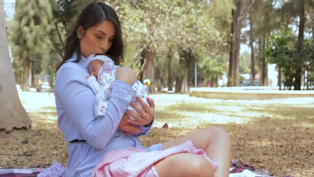 mamá acaricia a su bebe en parque