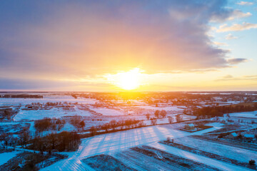Aerial view of winter snow-covered countryside at sunset