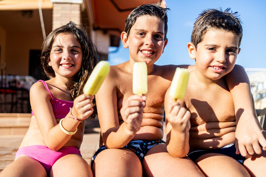 Three Funny Kids Eating An Ice Lolly