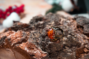 Bronze ring with a large amber stone on a wooden background
