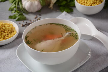 Chicken soup , chicken broth, with pieces of chicken and vegetables and shkedei marak an Israeli food product crisp mini croutons used as a soup accompaniment