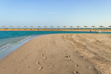 Sunset on the beach with parasol overlooking the Red Sea in Hurghada, Egypt