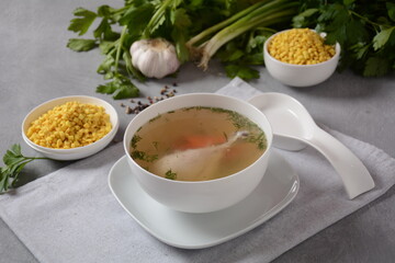 Chicken soup , chicken broth, with pieces of chicken and vegetables and shkedei marak an Israeli food product crisp mini croutons used as a soup accompaniment
