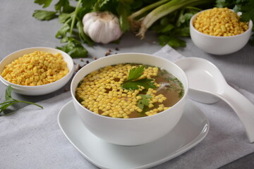 Chicken soup , chicken broth, with pieces of chicken and vegetables and shkedei marak an Israeli food product crisp mini croutons used as a soup accompaniment